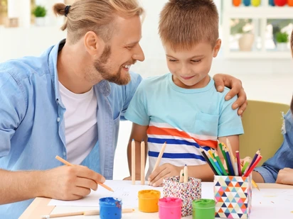 Family with young children gathered at a table with art supplies