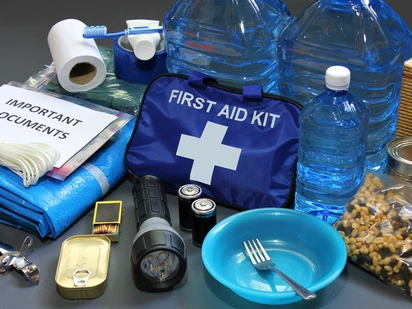 Items from emergency kit, first aid kit, bottles of water, flashlight, batteries.