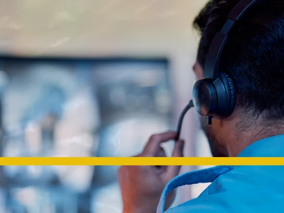 911 telecommunicator with a headset looking at a computer screen 