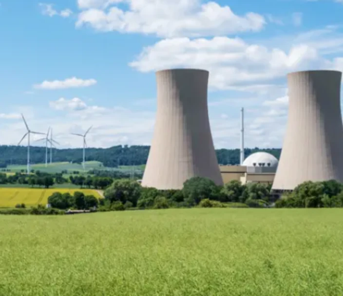 Nuclear power plant in the distance near wind turbines.