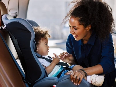 Woman placing child into car seat