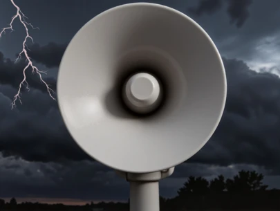 Outdoor siren with storm clouds and lightning in background