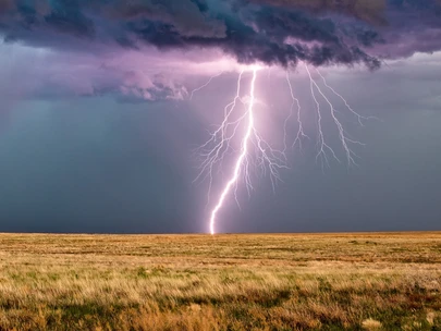 Severe thunderstorm with lightning striking a field