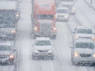 Vehicles driving through intense snow on interstate