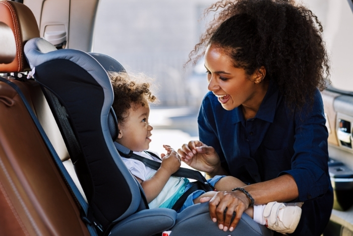 Woman placing child into car seat
