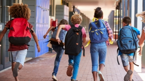 Kids running down school hallway