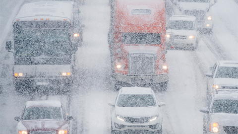 Vehicles driving through intense snow on interstate