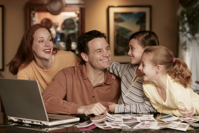 Family looking at laptop and brochures making an emergency plan