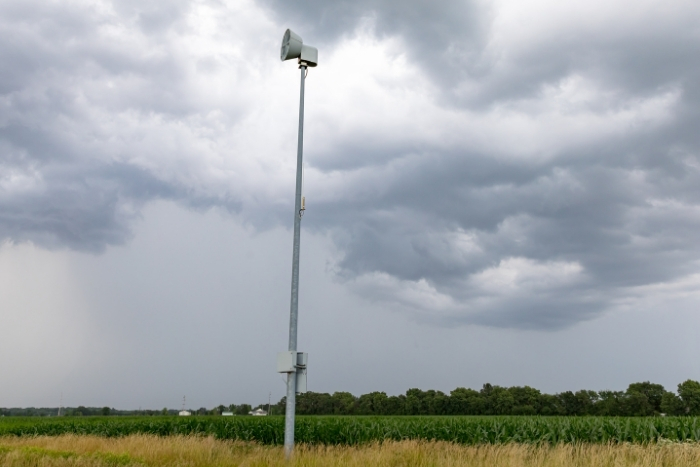 Weather Siren stands in cornfield amongst ominous clouds